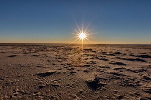 A beach with footprints and the sun low on the horizon. - Apartment in Juist with swimming pool (Juist)