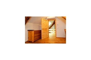 A room with a wooden bench, a wooden door, and a sloped ceiling. - Holiday home Lotus Hof Stallegg (Löffingen)