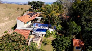 A residential property with a swimming pool, solar panels, and lush greenery. - Country house in Itatiba, São Sebastião retreat (Itatiba)