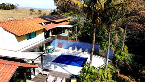 Una propiedad residencial con piscina, paneles solares y vistas del paisaje circundante.