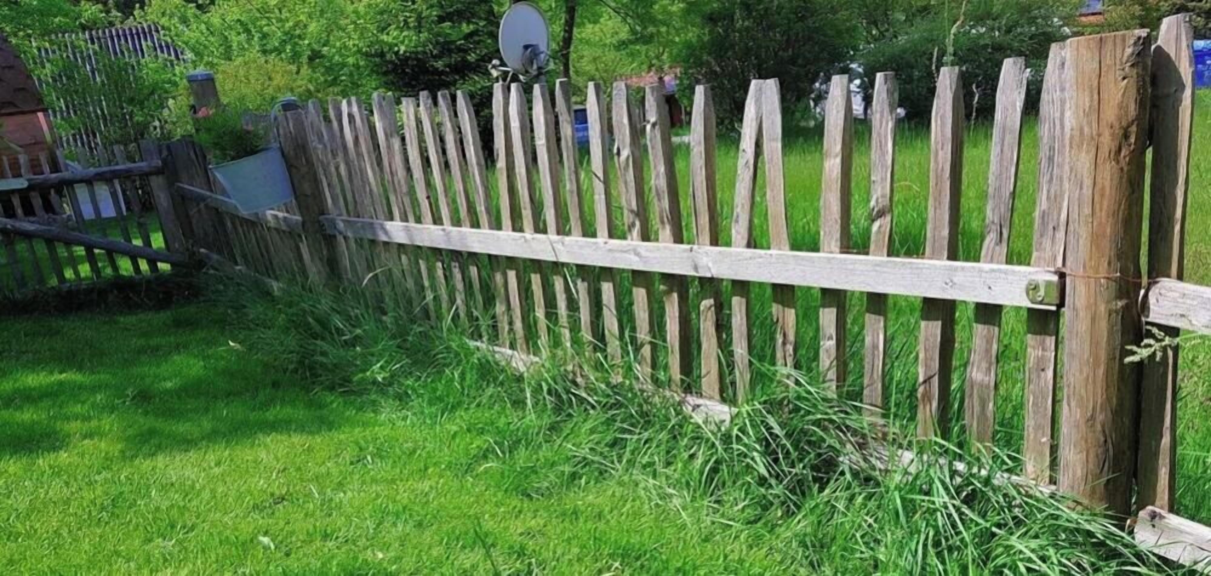 A wooden fence with a satellite dish attached to it.