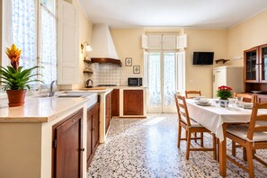 Une cuisine avec un coin repas, un réfrigérateur et un téléviseur.