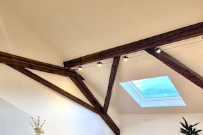 A room with exposed wooden beams, a skylight, and a ceiling light fixture. - Holiday apartment with 1 bedroom (Landau in der Pfalz)