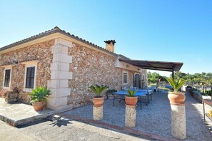 A stone building with a patio area, outdoor seating, and a ping pong table. - Cabin with 1 bedroom (Santa Margalida)