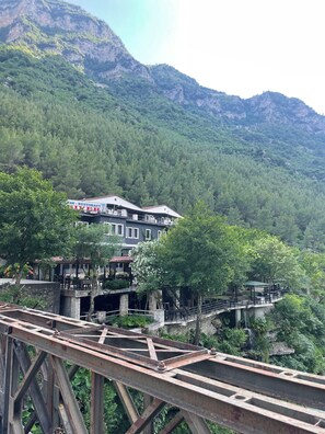 Un restaurante con terraza al aire libre que ofrece vistas a un paisaje montañoso.