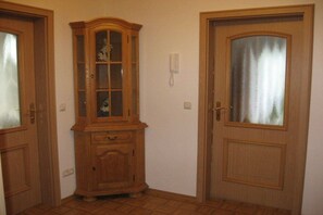 A corner room with two wooden doors, one with a frosted glass panel, and a wooden cabinet with glass doors. - House by the spa park (Bad Kohlgrub)