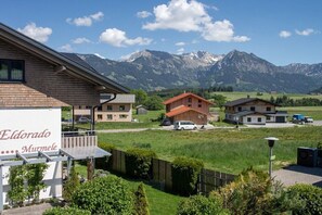 A hotel with a mountain view, a signboard, and a parking area. - Eldorado Holiday Apartment Dream Dancer (Bolsterlang)