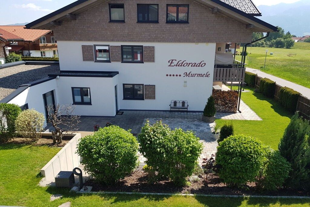 Ein zweistöckiges Gebäude mit weißer Fassade und einem Schild mit der Aufschrift 'Eldorado Murmelle'.