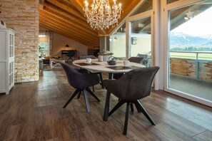 A dining area with a round table, chairs, and a chandelier. - Eldorado Holiday Apartment Fairy Tale (Bolsterlang)