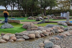 A landscaped area with a small stream, rocks, and a model building in the background. - Holiday apartment with 1 bedroom (Dollerup)