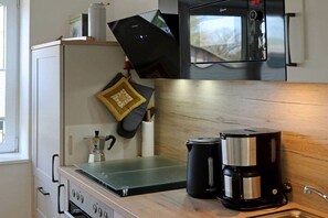 A kitchen with a coffee maker, a microwave, and a kettle on the countertop. - Holiday apartment with 1 bedroom (Dollerup)
