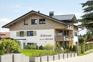 Ein zweistöckiges Gebäude mit einem Balkon und einem Schild, auf dem 'Eldorado Murmele' steht.