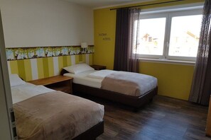 A hotel room with two beds, a window with curtains, and a wall with a tree pattern. - Eldorado Holiday Apartment Enchanted Forest (Bolsterlang)