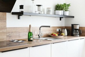 A modern kitchen with a built-in sink, a coffee maker, and a fruit bowl. - Holiday apartment with 2 bedrooms (Tönning)
