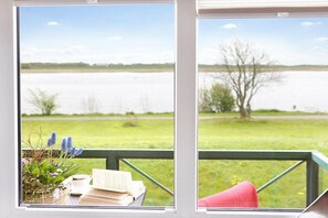A view from a window with a view of a body of water and a grassy area. - Holiday apartment with 2 bedrooms (Tönning)