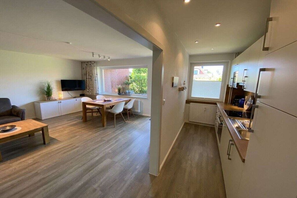 A modern apartment with a dining area, kitchen, and living room.