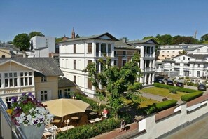 A hotel with a garden patio, outdoor seating, and a view of the surrounding buildings. - Holiday apartment with 1 bedroom (Heringsdorf (Seebad))