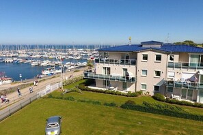 A modern building with a balcony overlooking a marina with numerous boats. - Holiday apartment 3 “Hanne Nüte” (Kühlungsborn)