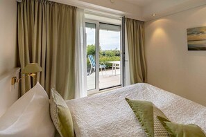 A hotel room with a bed, curtains, a window, and a view of the outdoors. - Holiday apartment 2 “Dörchläuchting” (Kühlungsborn)