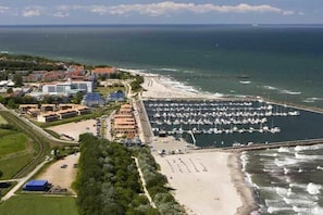 Eine Küstenlandschaft mit einer Marina, einem Strand und Gebäuden.