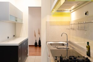 A modern kitchen with a stainless steel sink, a gas stove, and a built-in oven. - Lory House - My Rental Homes (Sorrento)