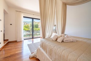 A bedroom with a large bed, a balcony with a view, and a sliding door. - Lory House - My Rental Homes (Sorrento)