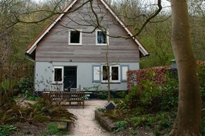 A two-story house with a front porch, a dining table, and a bench. - Holiday home with 2 bedrooms (Groot-Valkenisse)