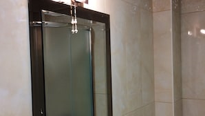 Un bagno con uno specchio grande, un portascopevoli, un dispenser di sapone e un asciugamani a soffitto.