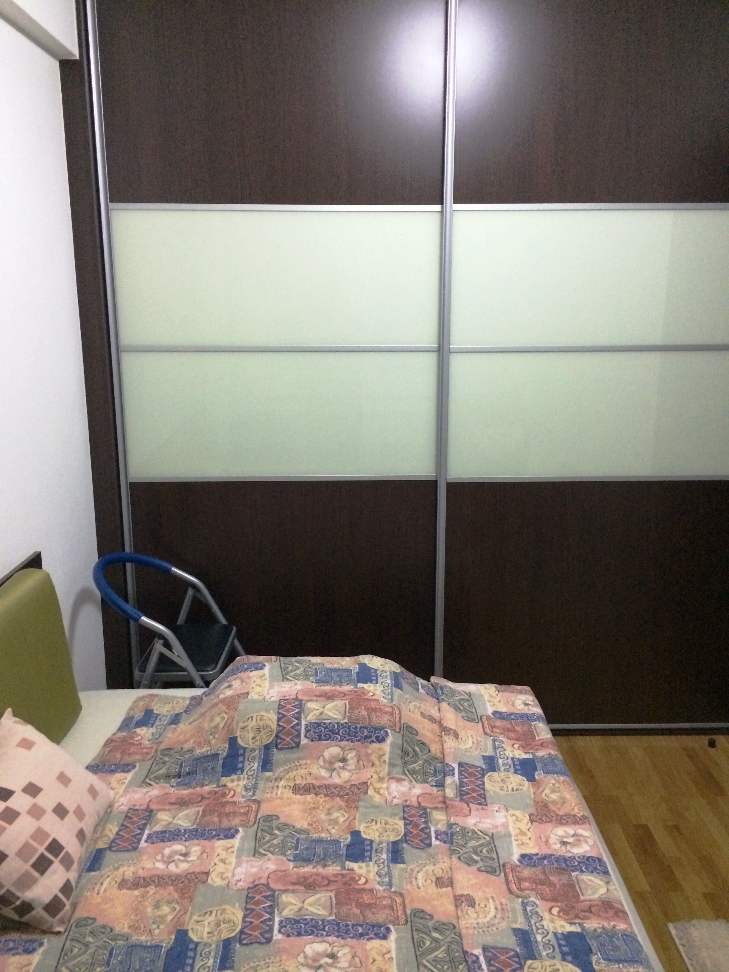 Ein Zimmer mit einem Bett, einem Sessel und Holzboden.