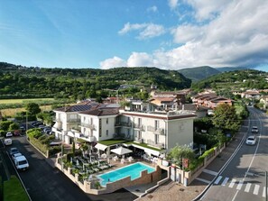 Un hotel con piscina, varios pisos y vistas del paisaje circundante.