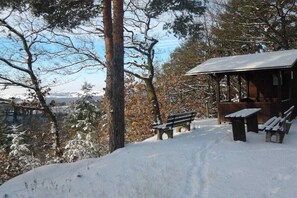 A wooden cabin with benches and a picnic table in a snowy landscape. - Villa on Bleidenberg (Oberfell)