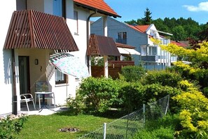 Un quartier résidentiel avec des maisons, une cour clôturée et une petite table avec des chaises.