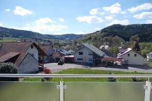 Ein Wohngebiet mit Häusern, einer Tankstelle und einer hügeligen Landschaft im Hintergrund.