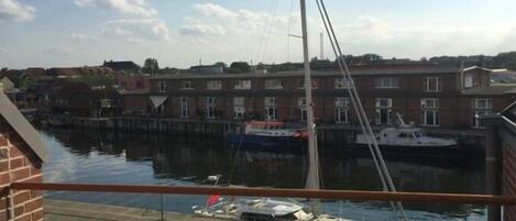A balcony with a view of a marina, boats, and buildings in the background.