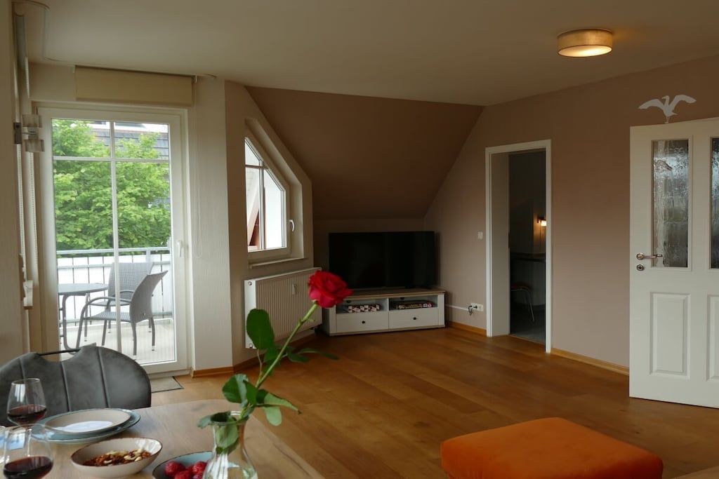 A room with a dining table, chairs, a television, and a door.