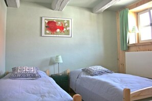 A room with two single beds, a framed picture on the wall, a bedside table with a lamp, and a window with curtains. - Holiday home in Tangermünde with Wi-Fi (Tangermünde)