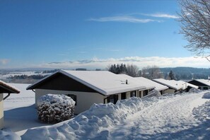 A row of cabins with snow-covered roofs and a clear sky. - Holiday home "Säuling" (Lechbruck)