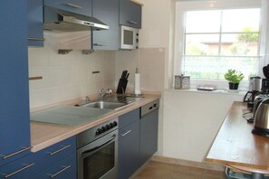 Eine Küche mit doppelter Spüle, Edelstahlgeräten und einem Fenster mit Blick.