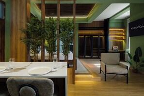 A modern dining area with a wooden table, chairs, and a potted plant. - Loft moderno para 2 personas | Plaza Bolívar, Casco Viejo. (Casco Viejo)