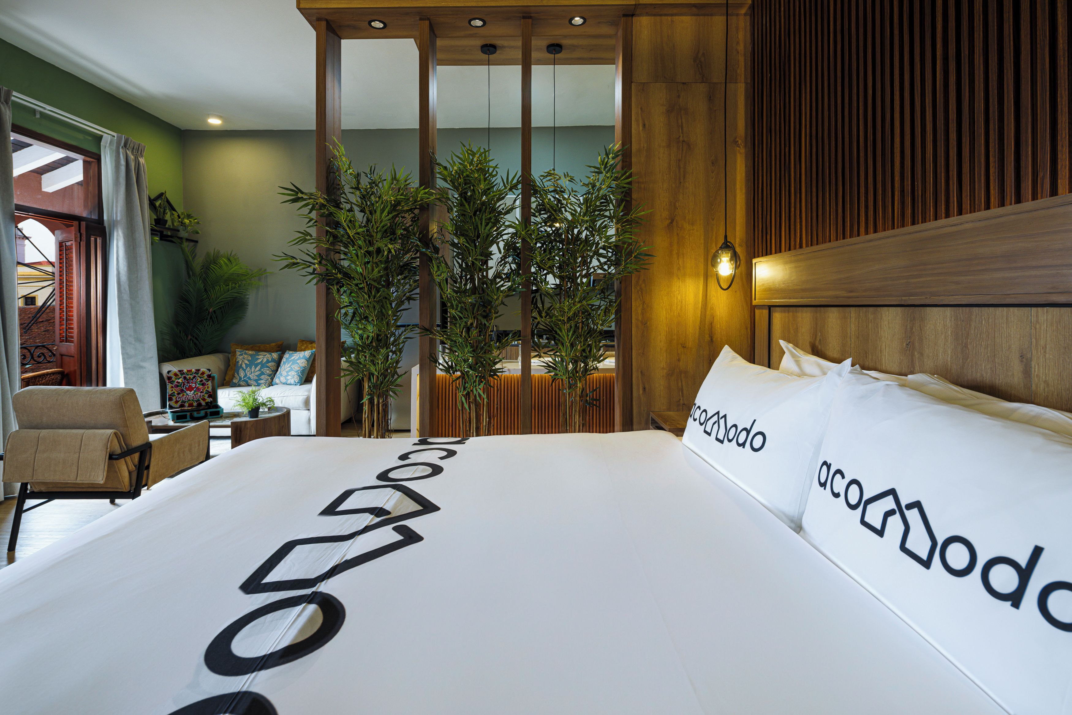 Una camera d'hotel con un letto grande, una testiera in legno e vista sulla città.