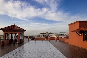 A rooftop terrace with patterned flooring, a gazebo, and a view of distant buildings. - Loft moderno para 2 personas | Plaza Bolívar, Casco Viejo. (Casco Viejo)