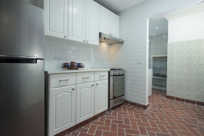 A kitchen with white cabinets, a stainless steel refrigerator, a built-in oven, and a tiled backsplash. - 2 Hab. + 1.5 Baños | Dúplex de dos niveles con balcón | Casco Viejo | Estadías de 30+ noches (Casco Viejo)