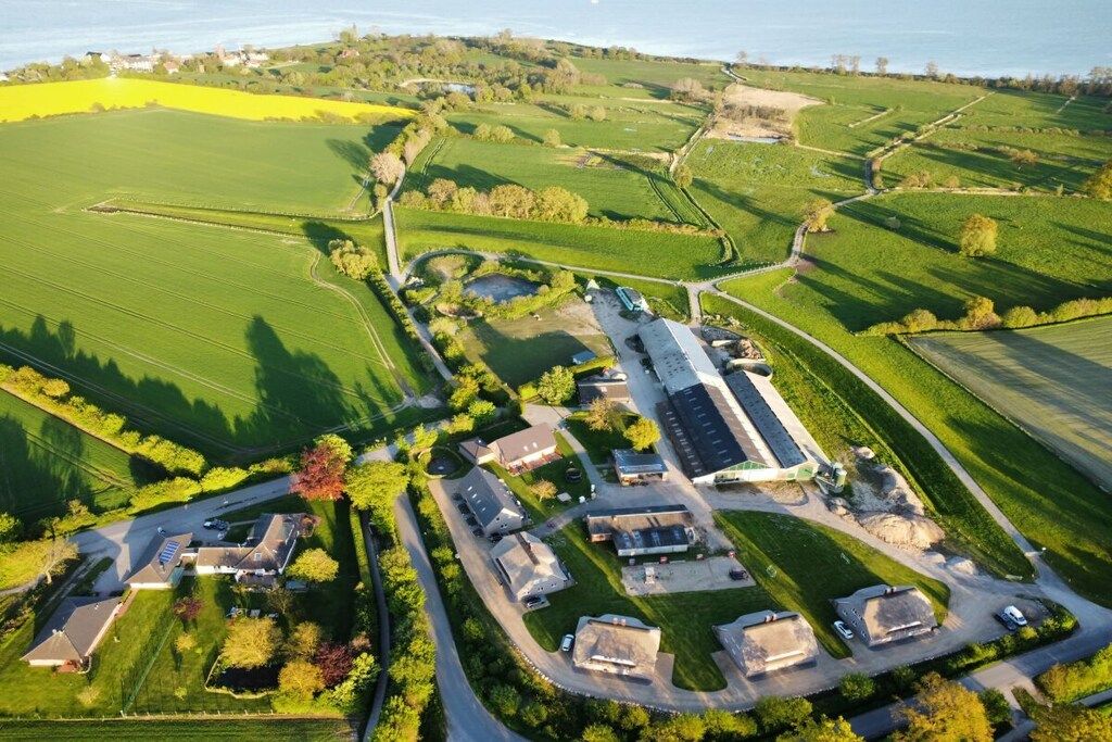 An aerial view of a rural property with multiple buildings, roads, and fields.