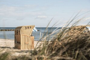 A beach chair with the number 381 on a sandy beach with the ocean in the background. - Holiday apartment with 1 bedroom (Schönberg)