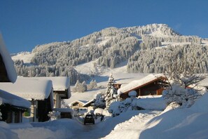A snow-covered mountain landscape with a wooden cabin and a car in the foreground. - Apartment in Bolsterlang with swimming pool (Bolsterlang)
