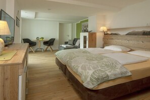 A hotel room with a bed, a desk with a lamp, a chair, and a small table with a plant. - Apartment in Bolsterlang with swimming pool (Bolsterlang)