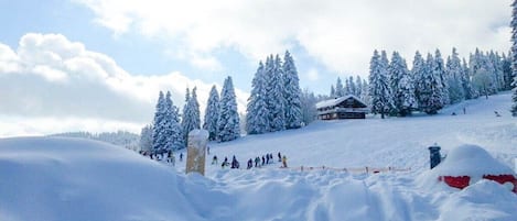 A snowy landscape with a ski resort, including a lodge and ski slopes.