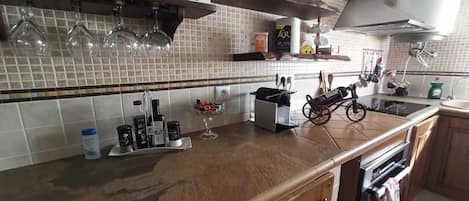 Ett kök med en bänkskiva, en hylla för te och en kaffemaskin.