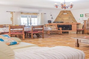 Ein Wohnzimmer mit Kamin, Essbereich und einer Couch.