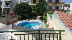 Un edificio residencial con piscina, balcones y cielo despejado.